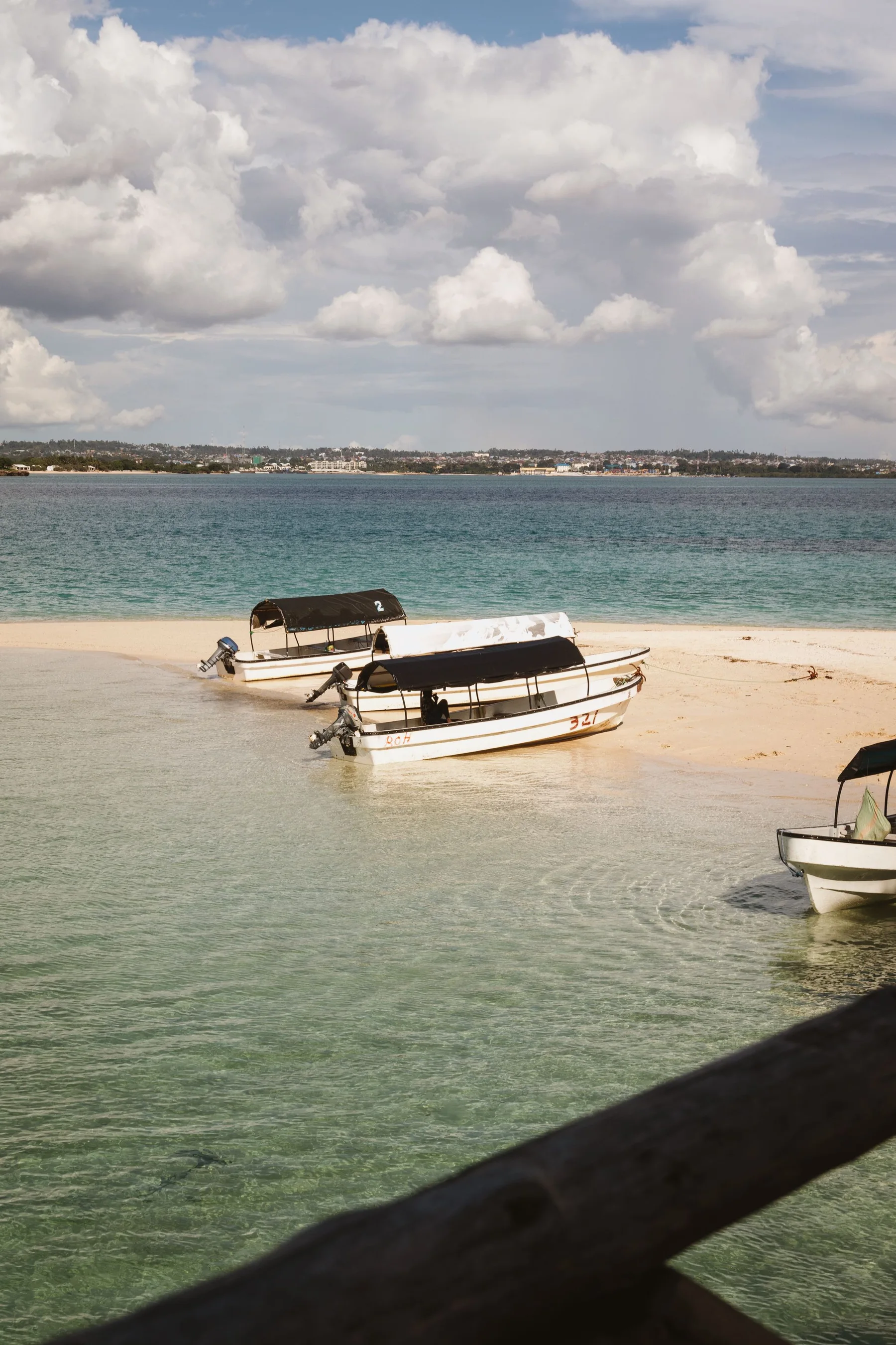 Boats resting in clear shallow water at Nungwi Beach, Zanzibar